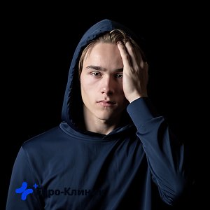 Парень в худи держится за голову